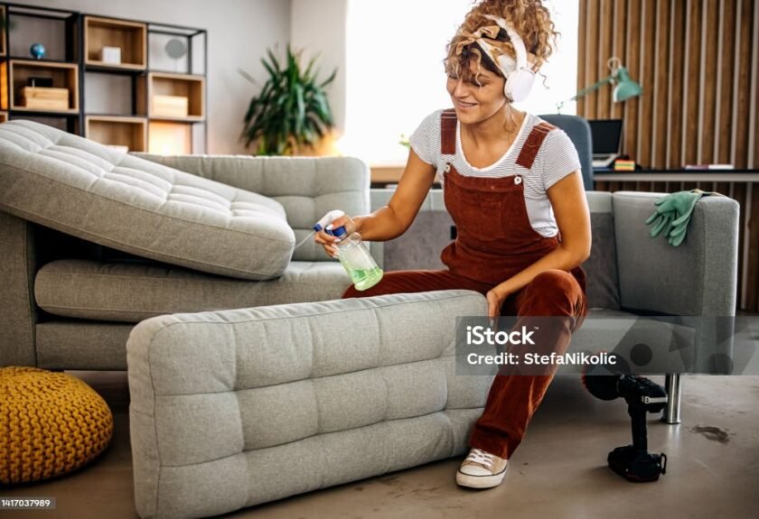 Cleaning process. Cleaner doing deep washing of sofa with professional equipment Cleaning Stock Photo