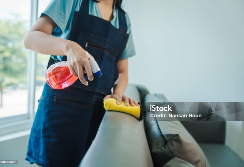 Cleans floor and desk. Hand of asian chinese woman wiping work desk, close-up. 20-24 Years Stock Photo